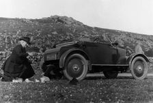 A woman picnicking next to her air-cooled Rover 8, c1919-c1925