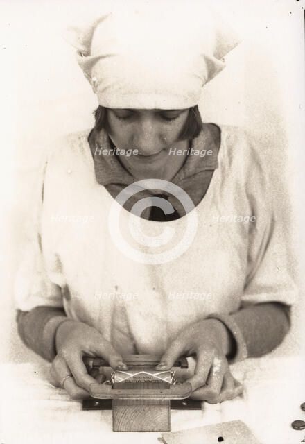 A woman seals the wrapper of a tube of Rowntree clear gums, Rowntree factory, York, 1929. Artist: Unknown