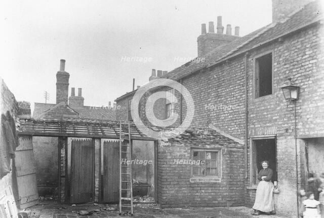 A woman stands in the back yard of a house, York, Yorkshire, 1923. Artist: Unknown