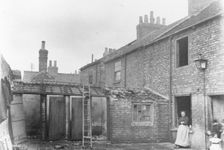 A woman stands in the back yard of a house, York, Yorkshire, 1923
