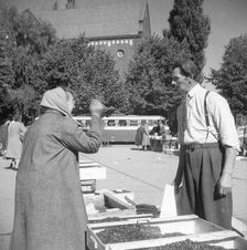A women buying lingonberries in the market square, Landskrona, Sweden, 1952