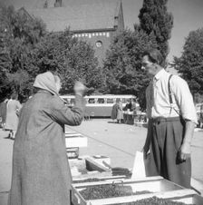 A women buying lingonberries in the market square, Landskrona, Sweden, 1952. Creator: Unknown