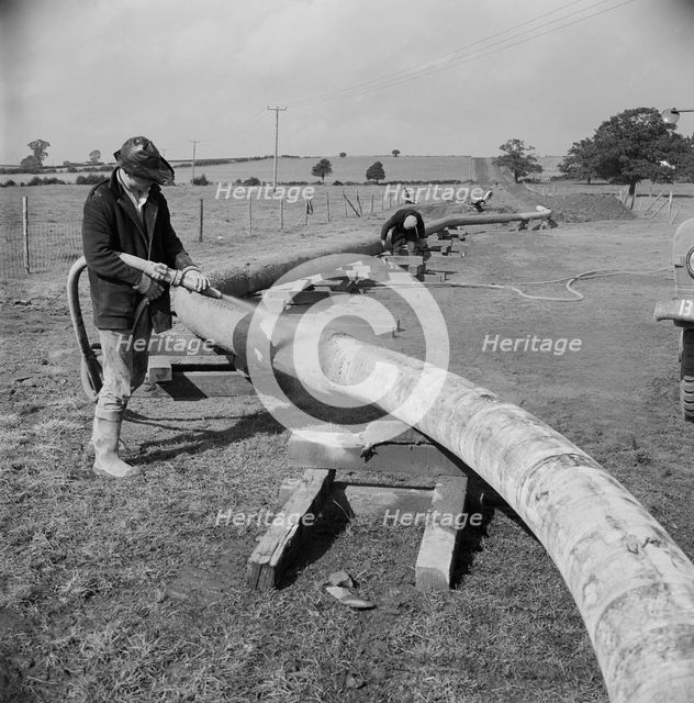 A worker carrying out guniting (spraying concrete) on the Mersey oil pipeline..., 24/09/1967. Creator: John Laing plc.