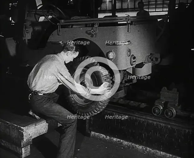 A Worker Fitting Wheels on a Car at an American Factory , 1942. Creator: British Pathe Ltd.