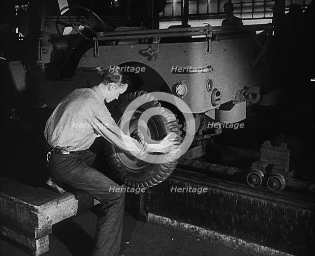 A Worker Fitting Wheels on a Car at an American Factory , 1942. Creator: British Pathe Ltd.