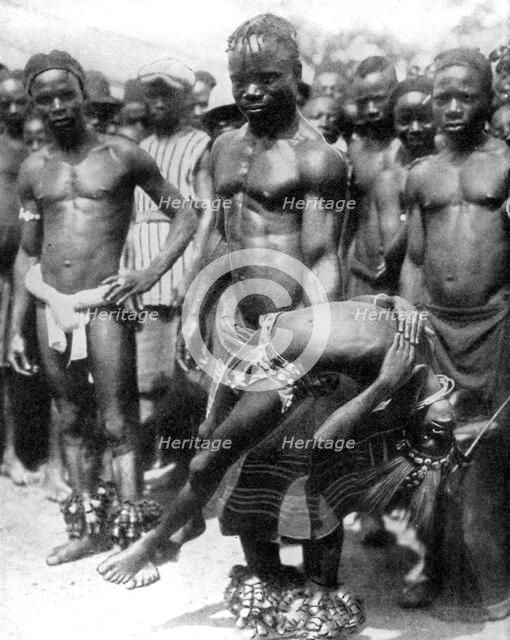 A Yafouba tribesman juggles with a girl, Ivory Coast, West Africa, 1936.Artist: Wide World Photos