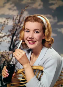 A young woman drinking a bottle of Coca-Cola, c1955. Creator: Arthur Charles Kirby Ware