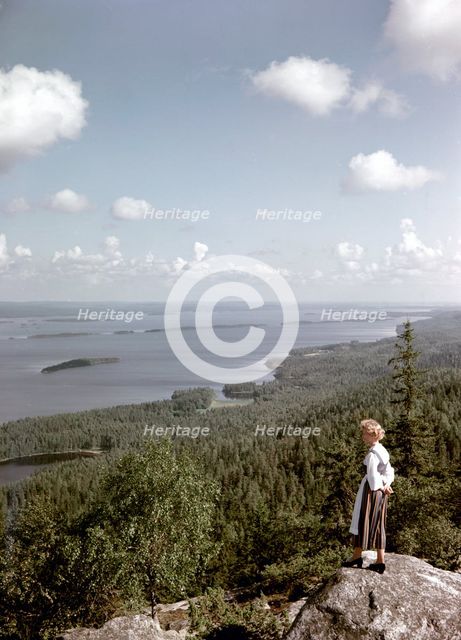 A young woman in traditional dresslooking out over Lake Pielinen, Koli district, Finland, 1960s. Artist: Göran Algård