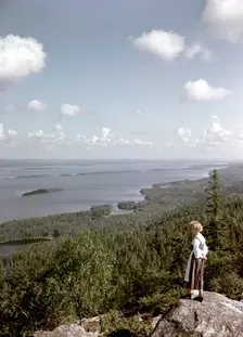 A young woman in traditional dresslooking out over Lake Pielinen, Koli district, Finland, 1960s. Creator: Göran Algård