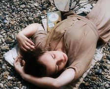 A Young Woman Lying on the Beach at Brighton With Her Eyes Closed With a Two Books to the..., 1939. Creator: British Pathe Ltd