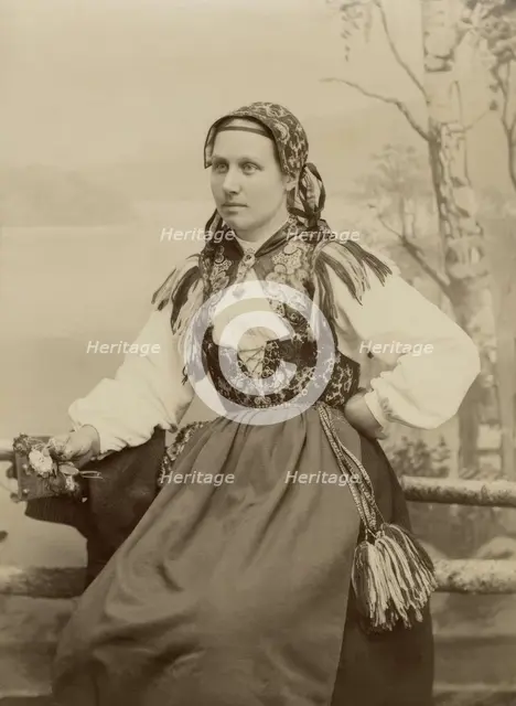 A young woman poses in a folk costume, 1890-1920. Creator: Helene Edlund.