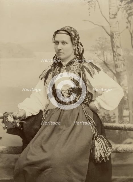 A young woman poses in a folk costume, 1890-1920. Creator: Helene Edlund.