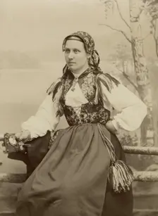 A young woman poses in a folk costume, 1890-1920. Creator: Helene Edlund