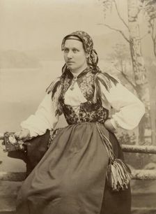 A young woman poses in a folk costume, 1890-1920. Creator: Helene Edlund