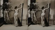 A young woman posing naked in a photographic studio, standing with her back to the camera..., c1900. Creator: Unknown