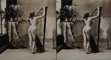 A young woman posing naked in a photographic studio, standing with her back to the camera..., c1900. Creator: Unknown