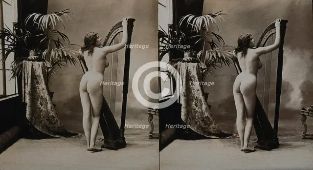 A young woman posing naked in a photographic studio, standing with her back to the camera..., c1900. Creator: Unknown.