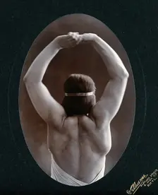 A young woman posing semi-naked, back view, with her arms in the air, in a photographic..., c1903. Creator: Unknown