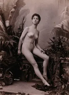 A young woman seated on a low balustrade posing naked, c1900. Creator: Unknown