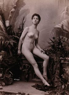 A young woman seated on a low balustrade posing naked, c1900. Creator: Unknown