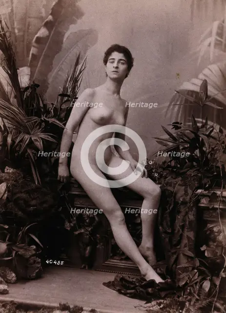 A young woman seated on a low balustrade posing naked, c1900. Creator: Unknown.