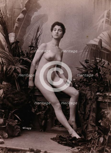 A young woman seated on a low balustrade posing naked, c1900. Creator: Unknown.