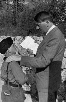 A young boy from the Hitler Youth shows Adolf Hitler a letter from his sick mother, 1936