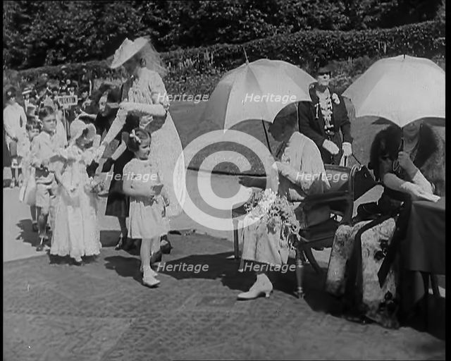 A Young British Girl Approaching the Chair of Queen Mary of Teck With a Purse in Her Hand..., 1939. Creator: British Pathe Ltd.