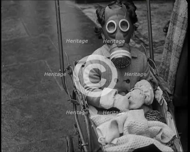 A Young Child in a Pram Wearing a Gas Mask, 1939. Creator: British Pathe Ltd.