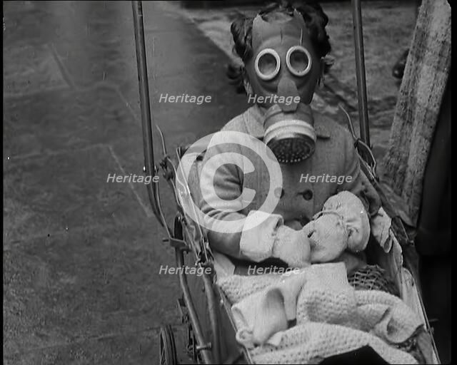 A Young Child in a Pram Wearing a Gas Mask, 1939. Creator: British Pathe Ltd.