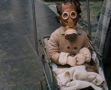 A Young Child in a Pram Wearing a Gas Mask, 1939. Creator: British Pathe Ltd