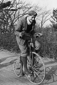 A young Lord Nuffield riding a bicycle down a country lane