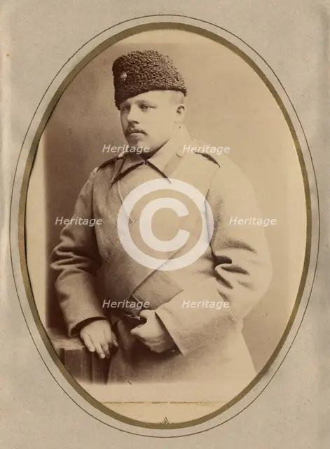 A young man in a fireman's uniform (overcoat and hat), late 19th cent - early 20th cent Creator: Shnee.