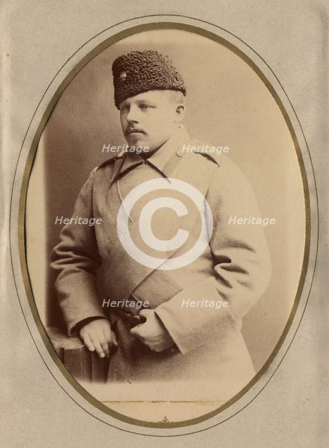 A young man in a fireman's uniform (overcoat and hat), late 19th cent - early 20th cent Creator: Shnee.