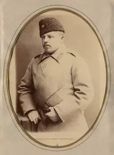 A young man in a fireman's uniform (overcoat and hat), late 19th cent - early 20th cent Creator: Shnee
