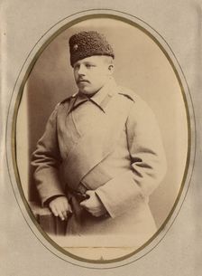 A young man in a fireman's uniform (overcoat and hat), late 19th cent - early 20th cent Creator: Shnee
