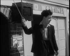 A Young Man in a Suit With an Open-Necked Shirt and Holding a Stick in One Hand is Drumming..., 1938 Creator: British Pathe Ltd