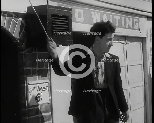 A Young Man in a Suit With an Open-Necked Shirt and Holding a Stick in One Hand is Drumming..., 1938 Creator: British Pathe Ltd.