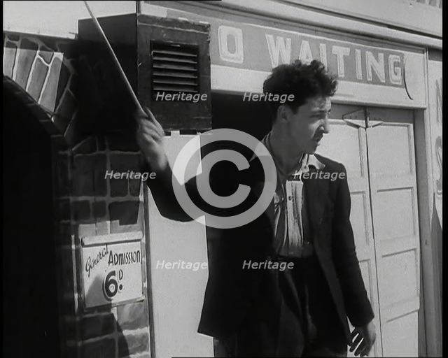A Young Man in a Suit With an Open-Necked Shirt and Holding a Stick in One Hand is Drumming..., 1938 Creator: British Pathe Ltd.