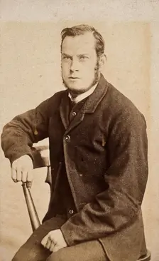 A young man, seated, with an intense expression in his eyes, c1890s. Creator: John Davis