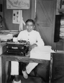 A young man sitting at a typewriter, Indonesia, 20th century