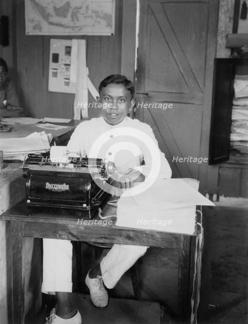 A young man sitting at a typewriter, Indonesia, 20th century. Artist: Unknown