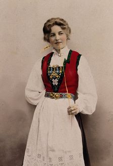 A young Norwegian woman, posing in a photographic studio wearing peasant dress, 1903. Creator: Solveig Lund
