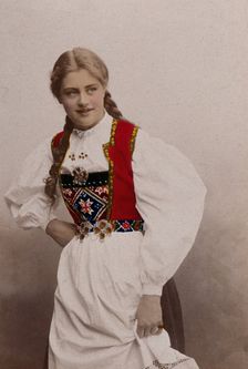 A young Norwegian woman, posing in a photographic studio wearing peasant dress, 1901. Creator: Sostrene Persen