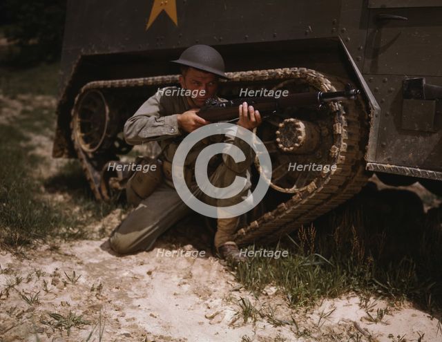 A young soldier of the armored forces holds and sights his Garand rifle..., Fort Knox, Ky, 1942. Creator: Alfred T Palmer.