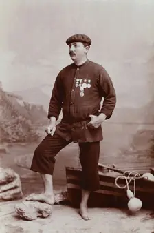 A barefoot Basque fisherman posing with several medals on his tunic, undated, estimated c1900s. Creator: Unknown