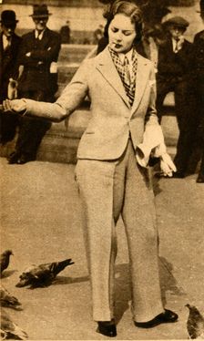 A betrousered lady feeding pigeons in Trafalgar Square 1933. Creator: Unknown