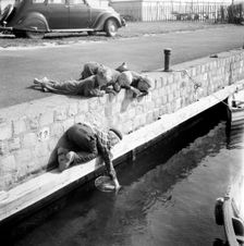 A boy catching crabs in the harbour of Landskrona, Sweden, 1954. Creator: Unknown