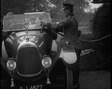 A British Automobile Association Employee Filling a Car With Petrol at a Petrol Station, 1920. Creator: British Pathe Ltd
