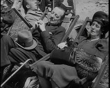 A British Couple Asleep in Deckchairs in the Sunshine in Hyde Park, the Man Has His Legs.., 1938. Creator: British Pathe Ltd